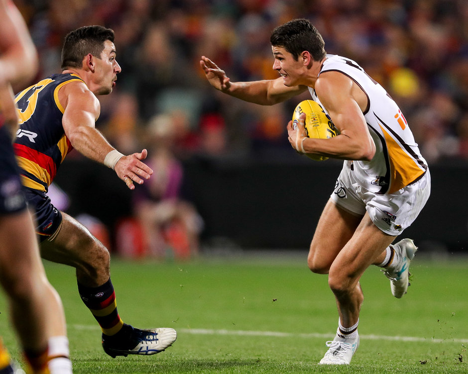 AFL 2017 Round 14 - Adelaide v Hawthorn ADELAIDE, AUSTRALIA - JUNE 22: Ryan Burton of the Hawks on his way to kicking a goal after evading Taylor Walker of the Crows during the 2017 AFL round 14 match between the Adelaide Crows and the Hawthorn Hawks at the Adelaide Oval on June 22, 2017 in Adelaide, Australia. (Photo by AFL Media)