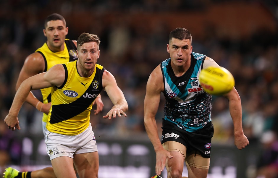 AFL 2018 Round 12 - Port Adelaide v Richmond ADELAIDE, AUSTRALIA - JUNE 08: Tom Rockliff of the Power and Kane Lambert of the Tigers compete for the ball during the 2018 AFL round 12 match between the Port Adelaide Power and the Richmond Tigers at Adelaide Oval on June 08, 2018 in Adelaide, Australia. (Photo by AFL Media)