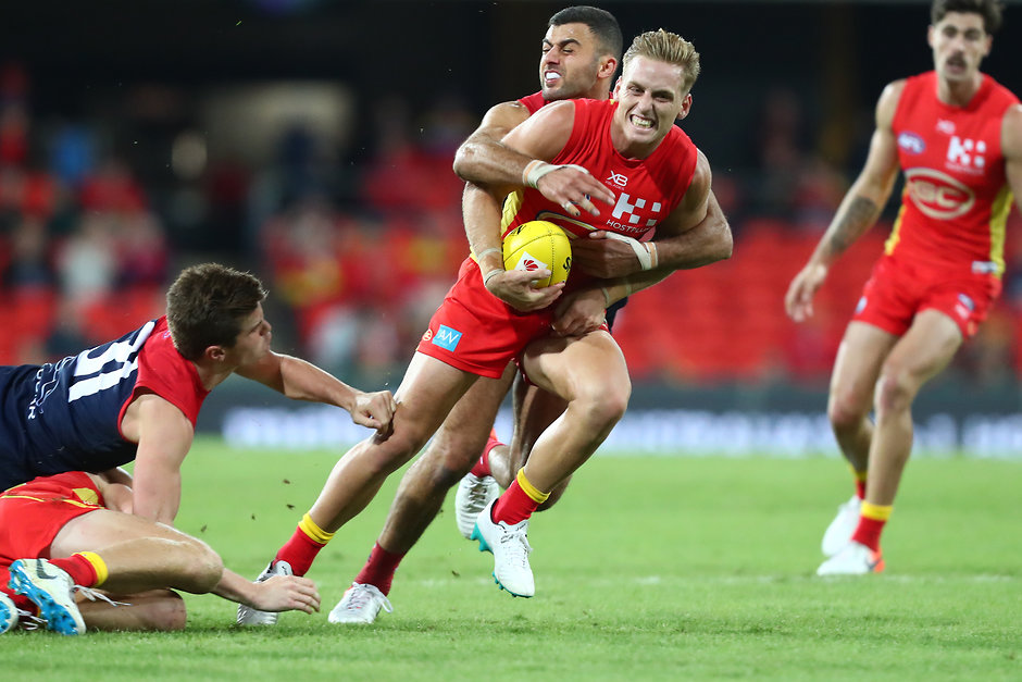 AFL 2019 Round 08 - Gold Coast v Melbourne GOLD COAST, AUSTRALIA - MAY 11: Darcy Macpherson of the Suns is tackled during the round eight AFL match between the Gold Coast Suns and the Melbourne Demons at Metricon Stadium on May 11, 2019 in Gold Coast, Australia. (Photo by Chris Hyde/Getty Images)